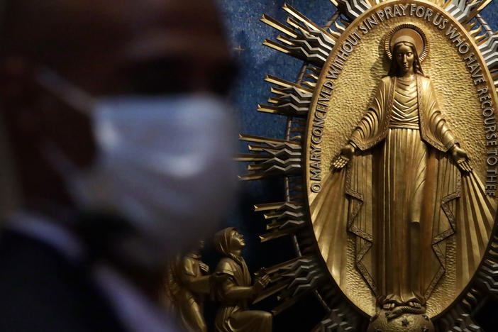 A member of the security personnel wears a mask during a Mass at the Basilica of the National Shrine of the Immaculate Conception in Washington, D.C.