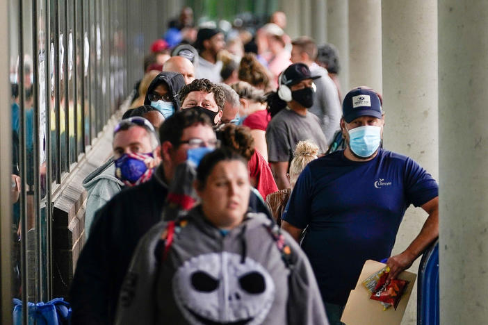 Hundreds of people line up outside a Kentucky Career Center hoping to find assistance with their unemployment claim in Frankfort, Ky., in June.