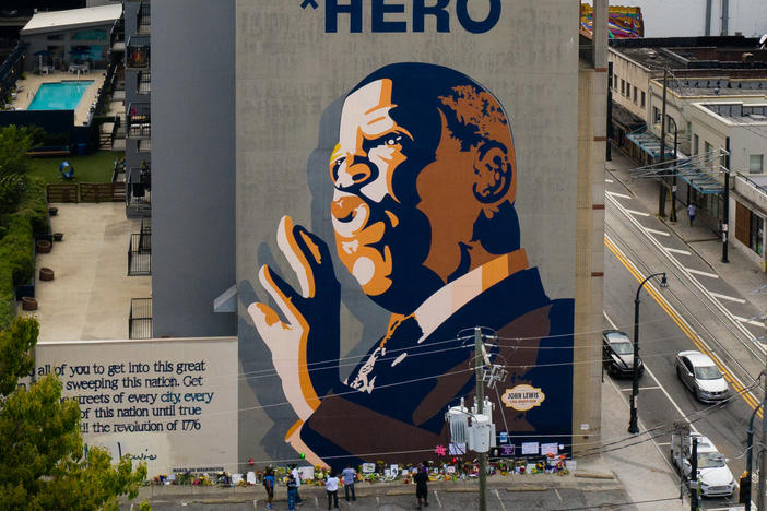 Mourners pay their respects at a mural of Rep. John Lewis painted on a building in Atlanta. The civil rights icon and congressman died on Friday.