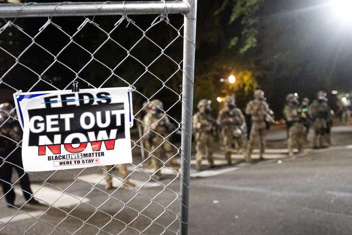 Federal agents disperse protesters near the Mark O. Hatfield U.S. Courthouse on Monday in Portland, Ore. State and local officials say the federal law enforcement officers have incited violence in the city.