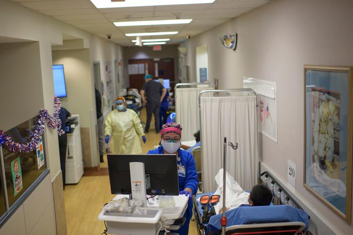 A health care worker talks to a patient in the emergency room at OakBend Medical Center in Richmond, Texas, on July 15.