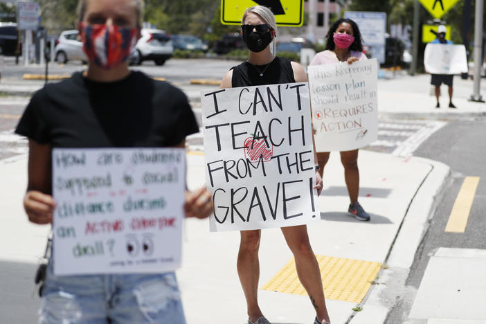 Middle school teacher Brittany Myers (center) stands in protest last week at the Hillsborough County School District Office in Tampa, Fla. Teachers and administrators have rallied against the reopening of Florida schools due to concerns about the coronavirus.