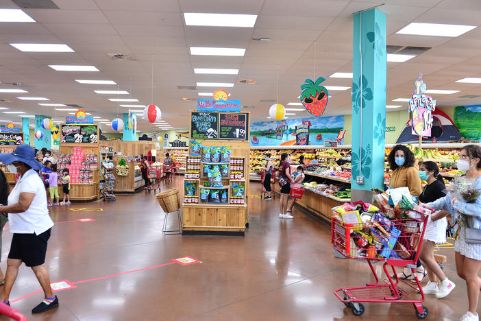 Trader Joe's says it is in the process of discontinuing some of its product branding. Here, shoppers buy groceries at a store last week in Pembroke Pines, Fla.
