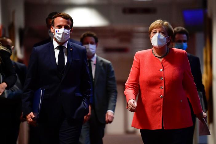 French President Emmanuel Macron and German Chancellor Angela Merkel arrive for a joint news conference at the end of the European summit at EU headquarters in Brussels on Tuesday.