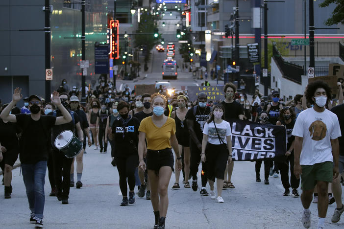 Protesters walk down a street Friday in Kansas City, Mo. They were demanding police reforms and an end to Operation LeGend, which is deploying 200-plus federal law enforcement agents in the city.