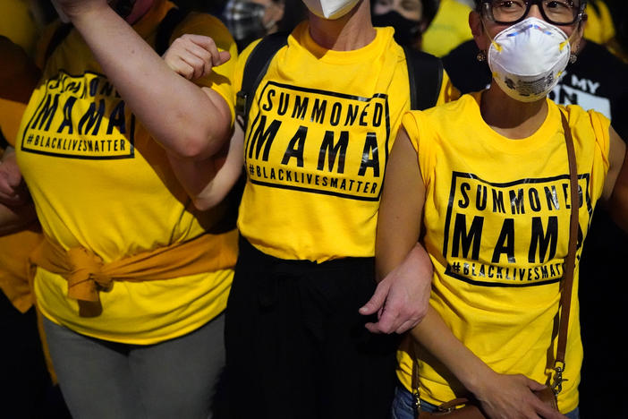 Members of the "Wall of Moms" protest group stand arm in arm during a protest at the Mark O. Hatfield U.S. Courthouse on Tuesday in Portland, Ore.