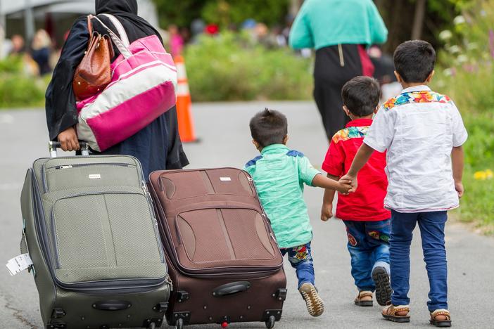 Asylum-seekers walk along Roxham Road near Champlain, N.Y., in August 2017, a popular illegal border crossing into Canada, away from official ports of entry.