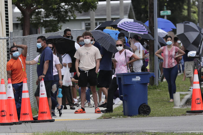 People wait in line outside a testing site in Florida. The state has seen unprecedented surges in coronavirus cases in recent weeks.