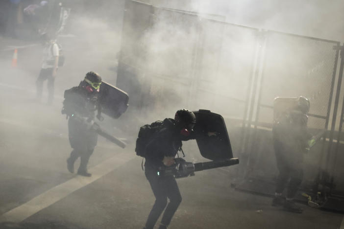 Demonstrators use leaf blowers to try to blow back tear gas launched by federal officers during a Black Lives Matter protest at the Mark O. Hatfield United States Courthouse on Sunday in Portland, Ore.