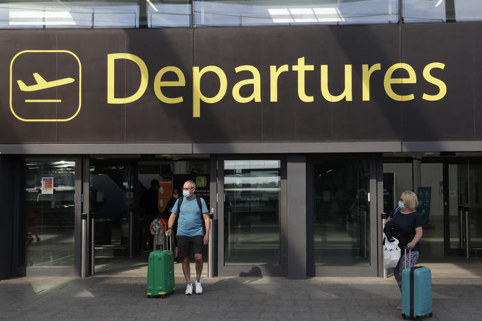 Parts of the European Union are at risk of a new wave of coronavirus cases, U.K. Prime Minister Boris Johnson says. The bloc began lifting many internal border restrictions last month. Here, airline passengers walk out of a departures area last week at Gatwick Airport, south of London.