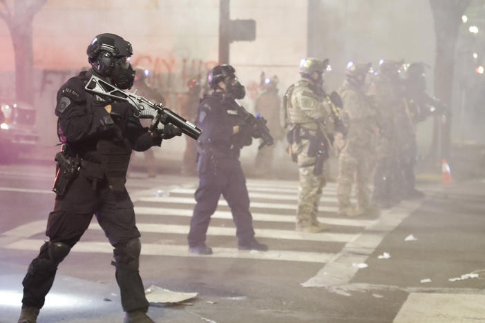 Federal officers deploy tear gas and crowd control munitions at demonstrators during a Black Lives Matter protest Tuesday at the Mark O. Hatfield U.S. Courthouse in Portland, Ore.