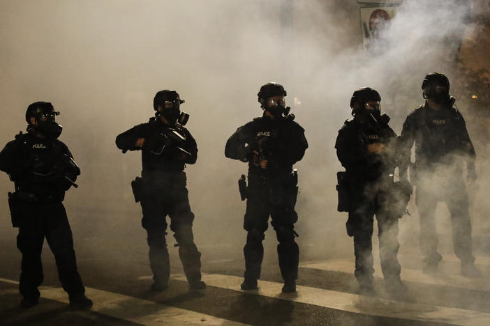 Federal officers are surrounded by smoke as they push back demonstrators during a Black Lives Matter protest at the Mark O. Hatfield United States Courthouse on Wednesday in Portland, Ore.