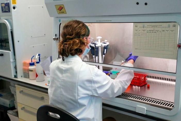 A scientist is pictured working during a visit by Britain's Prince William, Duke of Cambridge (unseen), to Oxford Vaccine Group's laboratory facility at the Churchill Hospital in Oxford, west of London on June 24, 2020, on his visit to learn more about the group's work to establish a viable vaccine against coronavirus COVID-19.