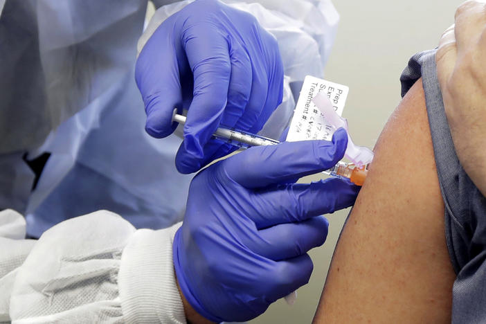 A patient in a first-stage study of a potential vaccine for COVID-19 receives a shot in March at the Kaiser Permanente Washington Health Research Institute in Seattle.