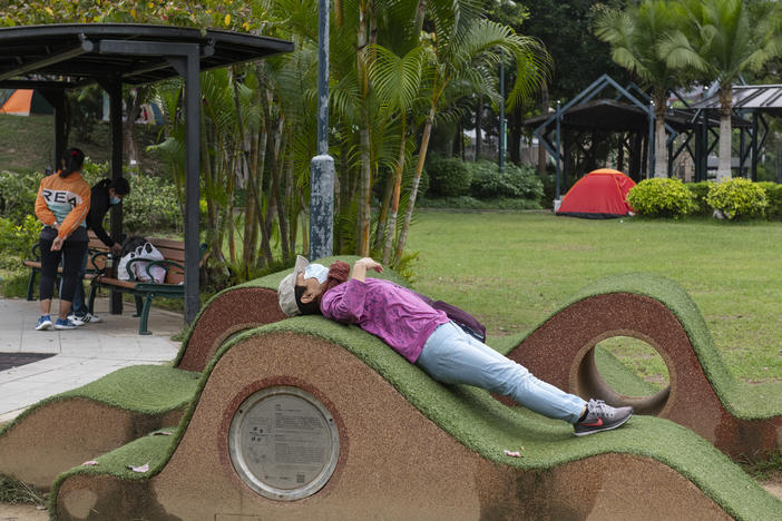 New rules in Hong Kong require everyone to wear a mask in all outdoor places or face a $650 fine. Above: A masked woman stretches out a public park. Also: The maximum number of people allowed at a public gathering is ... 2.