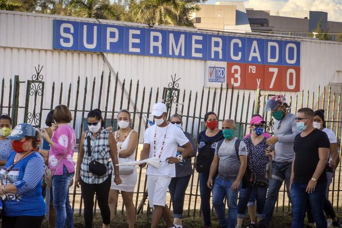 People wait to buy products with U.S. dollars at a supermarket in Havana on July 20. Cuba has eliminated a tax on dollars and opened "dollar stores" in an attempt to boost the economy.