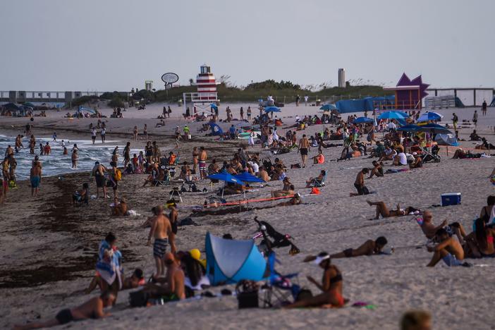 People relax on the beach in Miami Beach on Tuesday.