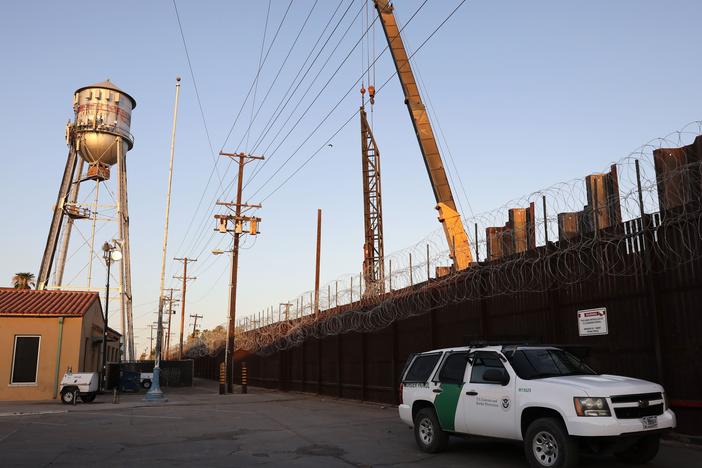 A U.S. Border Patrol vehicle is stationed in front of the U.S.-Mexico border barrier as construction continues in hard-hit Imperial County on July 22, in Calexico, Calif.