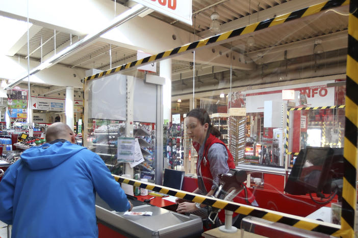 A cashier accepts payment from a customer in Munich in March.