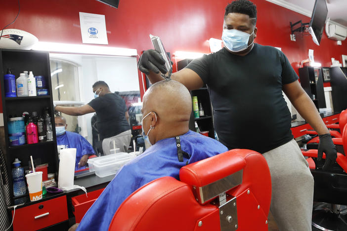Wilkin Soto works on a customer at the Castillo Barbershop, in Lawrence, Mass., on June 5. The pace of hiring has slowed from June, when employers added a record 4.8 million jobs.