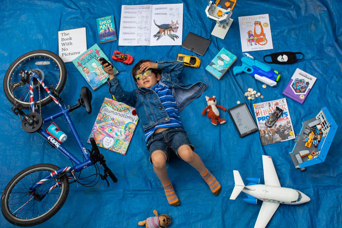 Elizabeth Dalziel's son Joe, 7, lays next to his favorite objects, toys and books as part of a homeschooling assignment — to create a time capsule — from his school in Berkhamsted, England.