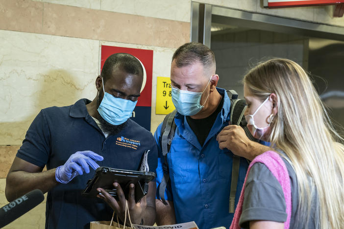 Members of the Test & Trace Corps meet travelers arriving by Amtrak from Miami at Penn Station in New York. Members of the Test & Trace Corps were out to educate visitors about quarantine restrictions for travelers from coronavirus hot spots.