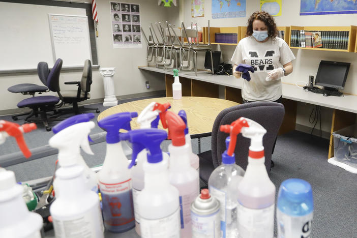 Charo Woodcock cleans a classroom at McClelland Elementary School in June in Indianapolis. Students across Indiana are already back in school in a mix of in-person and online instruction.