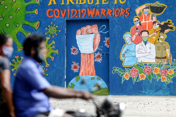 A mural in Chennai, India, celebrates workers on the front lines against the coronavirus pandemic. The global case count crossed the 20 million threshold on Monday, with the U.S., Brazil and India in the lead.