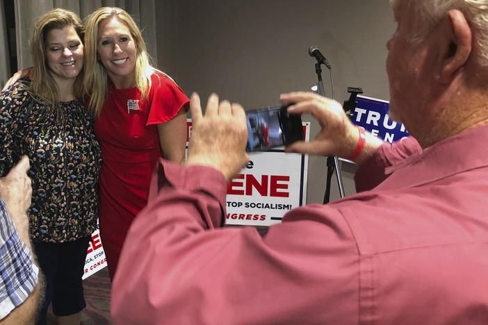 Marjorie Taylor Greene (right) is likely to bring a far-right conspiracy theory to the House of Representatives next year.