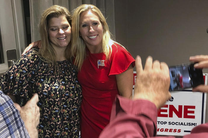 Marjorie Taylor Greene (right) poses with a supporter in Rome, Ga., late Tuesday. Greene, criticized for promoting bigoted videos and supporting the far-right QAnon conspiracy theory, won the GOP nomination for Georgia's 14th Congressional District.