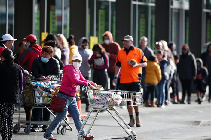 People line up outside a supermarket in a suburb of Auckland, New Zealand, on Wednesday before a three-day lockdown goes into effect. Four new COVID-19 cases were diagnosed in Auckland, and an additional four probable cases have been identified.