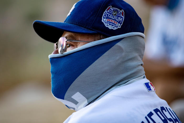 A fan wears a neck gaiter as he watches the Los Angeles Dodgers play at home against the San Francisco Giants last week.