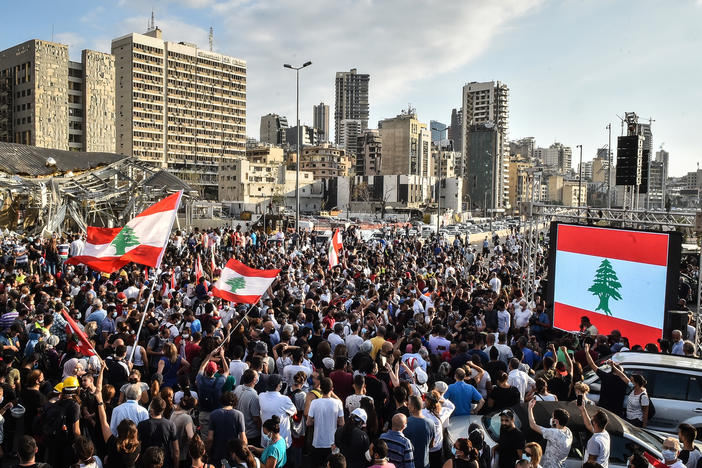 People wave Lebanese flags at a protest near the Beirut port on Tuesday. Last week's explosion has prompted new hopes for political change, but enormous challenges remain.