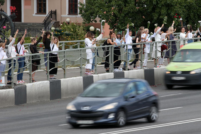 Women hold flowers Thursday in support of demonstrators who were injured or detained during protests critical of election results in Belarus.