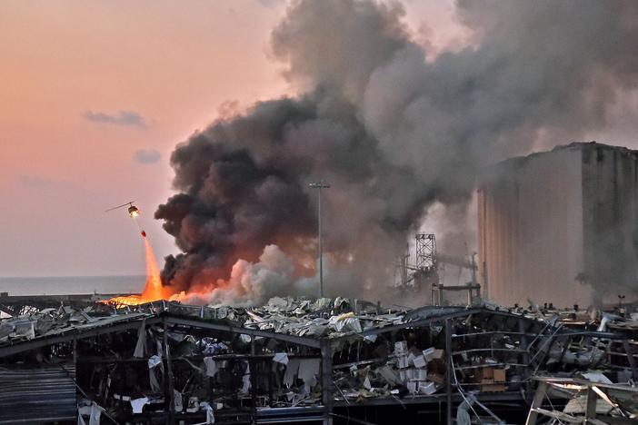 A helicopter puts out a fire at the scene of an explosion at the port of Lebanon's capital Beirut on Aug. 4.
