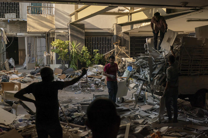 Workers remove debris from a hospital that was heavily damaged in last week's explosion that hit the seaport of Beirut.