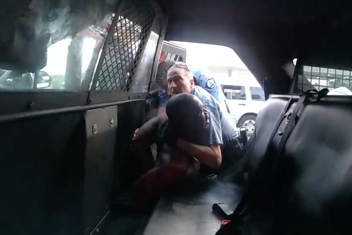 Minneapolis Officer Derek Chauvin is seen struggling to force George Floyd into the back seat of a police SUV in newly released body camera video recorded by Officer Tou Thao. Both Chauvin and Thao were fired, along with two other officers involved in Floyd's death on Memorial Day. All four former officers are facing charges.