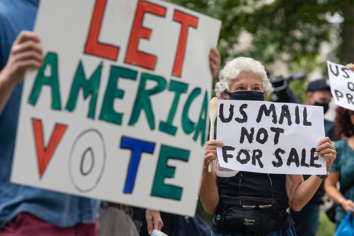 Demonstrators prepare to march Saturday to the home of Postmaster General Louis DeJoy in Washington, D.C.