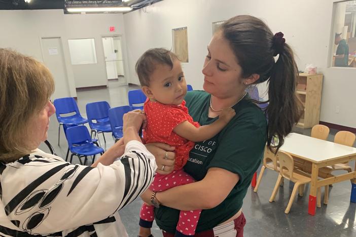 Dr. Goza listens to the lungs of a 2-year-old at Catholic Charities' Humanitarian Respite Center in McAllen, TX. After the toddler was released from CBP, she was sent to the emergency room with pneumonia and an undiagnosed congenital heart condition.