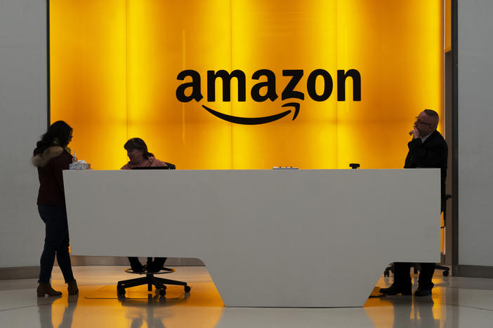 People stand in the lobby of Amazon offices in New York in January 2019. At a time of mass work from home and many moving to spacious suburbs, Amazon is funding a large expansion of corporate real estate and jobs in New York and five other U.S. cities.