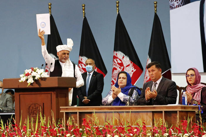 Afghan President Ashraf Ghani holds up a resolution on the last day of a traditional council known as a Loya Jirga, in Kabul, Afghanistan, Aug. 9. The council concluded with hundreds of delegates agreeing to free 400 Taliban members, paving the way for an early start to negotiations between Afghanistan's warring sides.