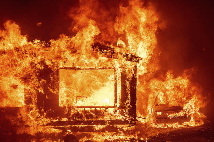 A mobile home and car burn at Spanish Flat Mobile Villa as the LNU Lightning Complex fires tear through unincorporated Napa County, Calif., on Tuesday.