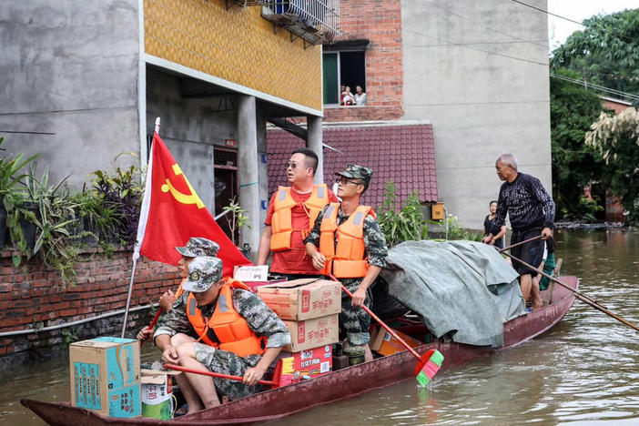 Community workers and volunteers deliver food and supplies to flood-affected residents after heavy rains in Neijiang in China's southwestern Sichuan province on Wednesday.