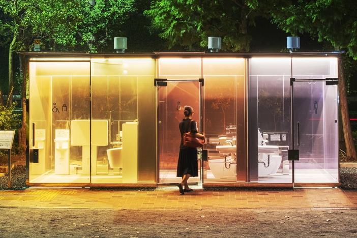 A woman enters a public restroom with transparent walls in Tokyo's Shibuya ward. Architect Shigeru Ban designed the bathroom in a way to reassure anyone entering the toilet.