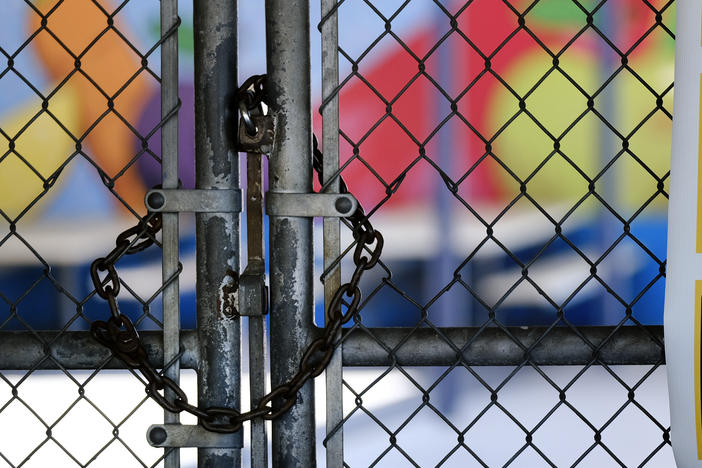 A chain-link fence lock is seen on a gate at a closed Ranchito Elementary School in the San Fernando Valley section of Los Angeles on July 13. Amid spiking coronavirus cases, the Los Angeles Unified School District is implementing a testing contact tracing plan.
