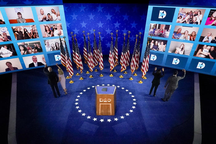 From left, on stage, Joe Biden, Jill Biden, Kamala Harris,and Doug Emhoff , wave to supporters connected virtually after Biden spoke Thursday night.