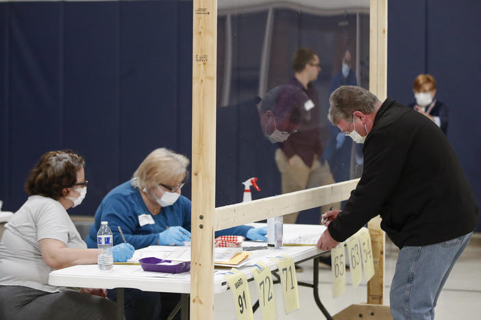 A man checks to cast his ballot in Kenosha, Wis., on April 7. A new study suggests that in-person voting in that Wisconsin primary did not produce a surge of new coronavirus cases.