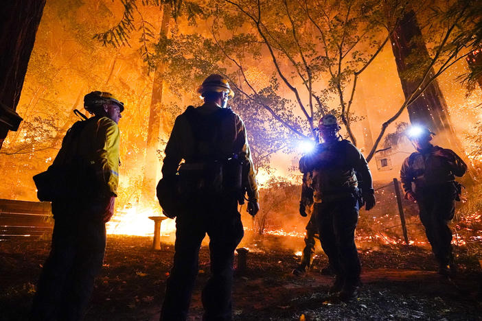 Firefighters make a stand in the backyard of a home in front of the advancing C.Z.U. Lightning Complex fire on Friday. California is seeing some of the worst first in the state's history.