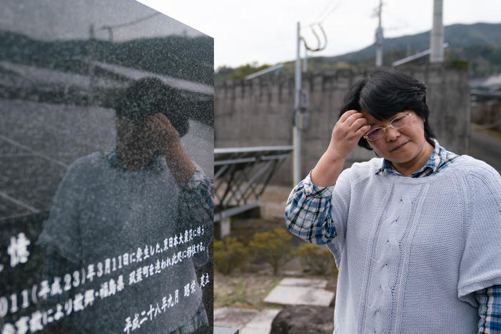 Chiyomi Endo stands beside her husband's grave. "Remember that this family evacuated Futaba town, Fukushima prefecture," the stone reads, "and moved here due to the nuclear accident following the Great East Japan Earthquake that occurred on March 11, 2011."