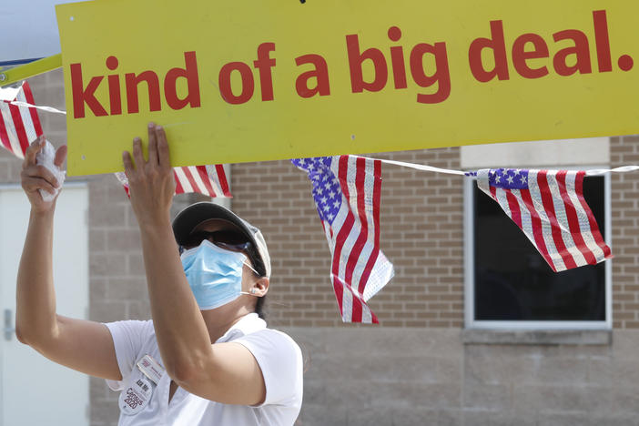 U.S. Census Bureau worker Marisela Gonzales adjusts a sign at a walk-up counting site for the 2020 census in Greenville, Texas, in July.